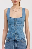 Close-up of denim lace-up corset top showing front tie and structured seams