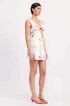 Side view of sleeveless mini dress with flared hem and bikini motif
