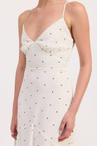 Close-up of white dress with black polka dots and wrap-style bodice