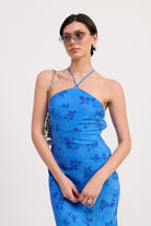 Blue floral midi dress with halter neckline and body skimming fit close up view