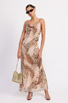 AVAH-Model wearing animal print cowl neck slip dress with gold chain bag and clear heels