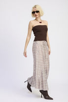 Model in plaid asymmetrical maxi skirt, side pose with movement