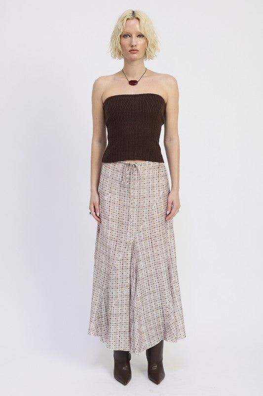 Model wearing asymmetrical plaid maxi skirt with strapless brown top, front view