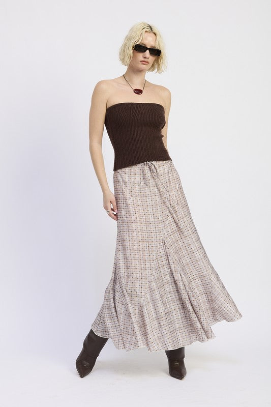 Model in plaid asymmetrical maxi skirt, side pose with movement