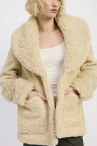 Close-up of beige taupe sherpa teddy coat with oversized collar and pockets
