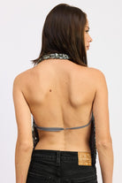 Back view of the silver sequin halter top showing open back with thin strap detail.