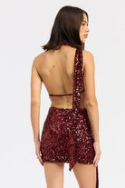 Back view of wine sequin mini dress showing open back and long scarf detail.
