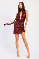 Full-body shot of wine sequin plunge mini dress with draped scarf accent.
