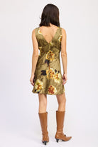 Back view of olive floral mini dress with tie detail and golden flower print