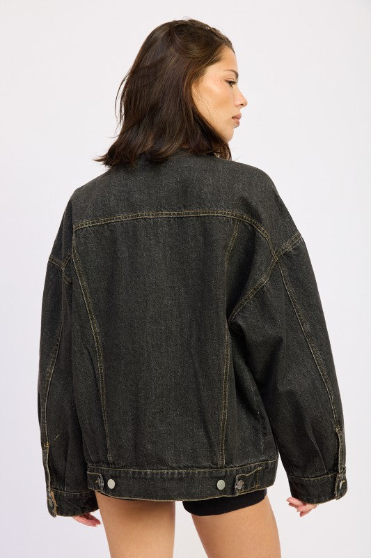Back view of oversized black denim jacket showing relaxed fit and adjustable hem.