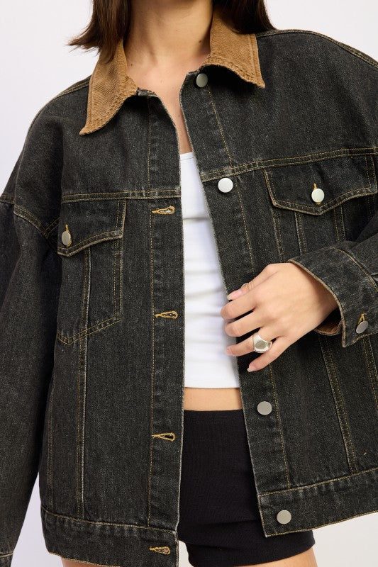 Close-up of black denim jacket showing tan corduroy collar and button-front detail