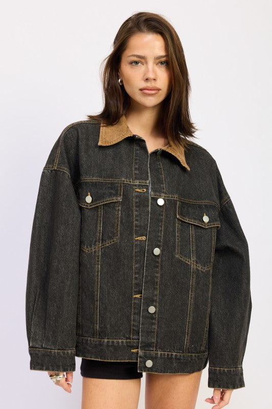 Model wearing an oversized black denim jacket with a tan corduroy collar, front view