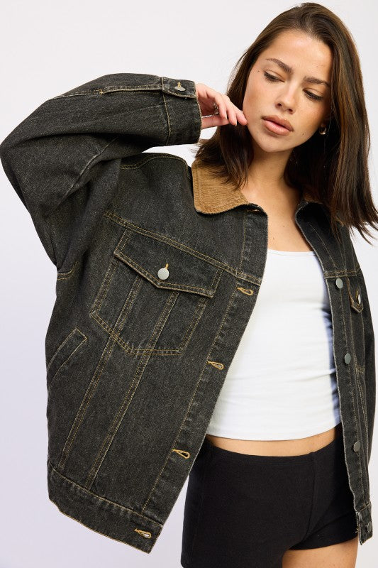 Model wearing oversized black denim jacket from a three-quarter side angle.