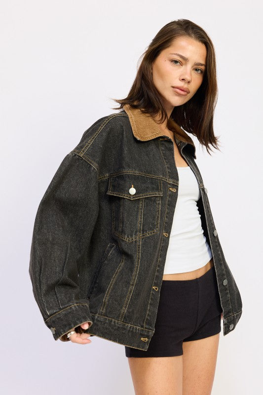 Model wearing oversized black denim jacket from a three-quarter side angle.