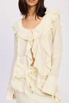 Chic cream ruffle blouse with flowing sleeves and tie cuffs