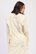 Back view of trendy cream ruffle blouse with shoulder ruffle accents