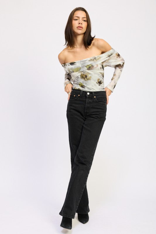 Model posing in AVAH off-shoulder ruched mesh bodysuit with long sleeves and fitted floral print.