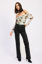 Full body view of AVAH floral mesh ruched bodysuit styled off-shoulder with straight-leg black jeans.