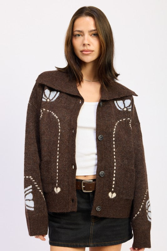 Woman wearing chocolate brown collared cardigan with floral intarsia knit, styled with white tank and black mini skirt-AVAH