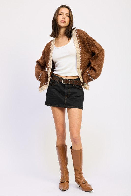 Full outfit with brown cardigan, black denim mini skirt, and tan boots.
