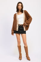 Full outfit with brown cardigan, black denim mini skirt, and tan boots.
