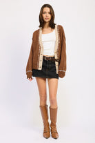 Full outfit with brown cardigan, black denim mini skirt, and tan boots.
