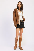 Full outfit with brown cardigan, black denim mini skirt, and tan boots.
