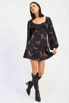 model wearing black floral mini dress with red blossoms and long puff sleeves-AVAH