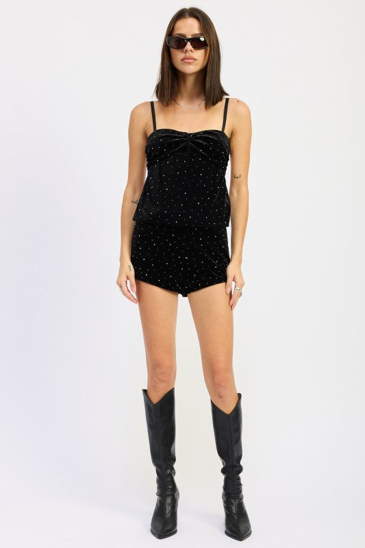 Model wearing black velvet rhinestone cami top and matching shorts styled with tall black boots.