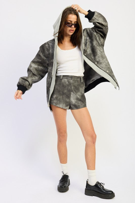 Full-body view of hooded mixed media jacket paired with matching shorts and platform shoes
