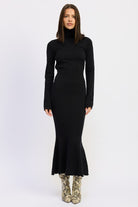 Model wearing the Sienna Whisper Open-Back Knit Dress in black, long sleeves, turtleneck, and mermaid hem.
