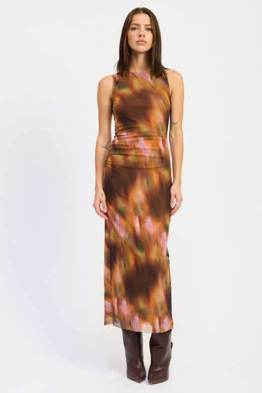 Model wearing sleeveless rust abstract print maxi dress with fitted silhouette and brown knee-high boots, front view.