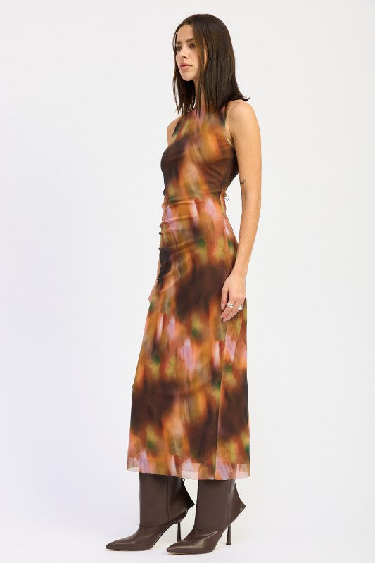 Side view of model in rust sleeveless maxi dress showing figure-hugging shape and back slit detail.
