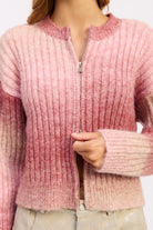 Close-up of pink ombre ribbed knit with front zipper detail.
