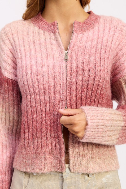 Close-up of pink ombre ribbed knit with front zipper detail.
