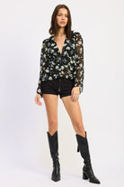 Full outfit featuring sheer floral blouse, shorts, and knee-high boots.
