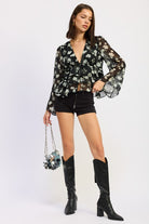 Full outfit featuring sheer floral blouse, shorts, and knee-high boots.
