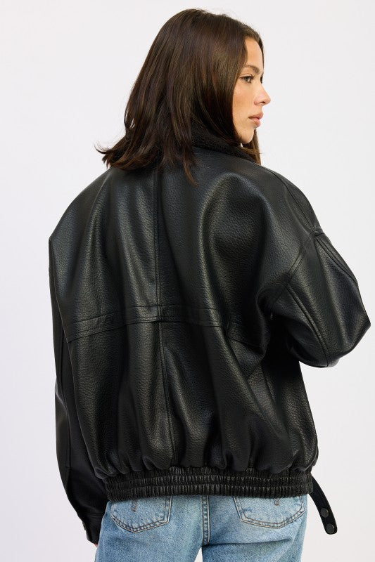 Back view of black vegan leather bomber jacket showing elasticized hem and relaxed silhouette.