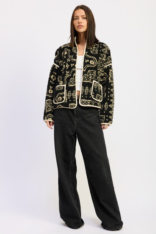 Full-body view showing sherpa jacket styled with black wide-leg pants.
