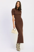 Model wearing mocha ribbed midi dress with short sleeves and snake boots.
