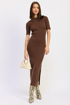 Model wearing mocha ribbed midi dress with short sleeves and snake boots.
