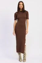 Model wearing mocha ribbed midi dress with short sleeves and snake boots.
