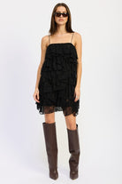 Front view of black tiered lace mini dress with ruffles and spaghetti straps.
