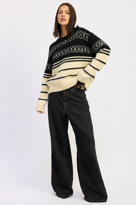 Full-body view of model wearing black and cream Fair Isle sweater with wide-leg black jeans