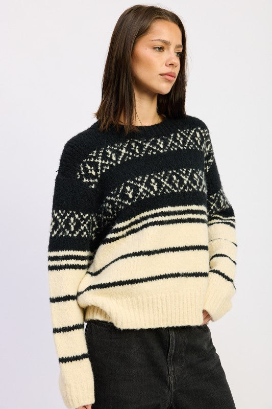 Side-angle view of model in black and cream Fair Isle crewneck sweater