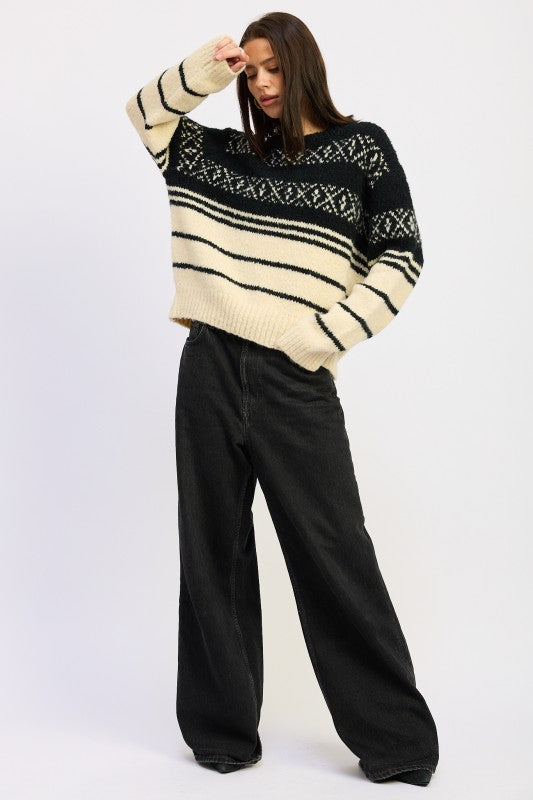 Full-body view of model wearing black and cream Fair Isle sweater with wide-leg black jeans