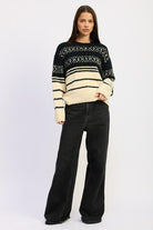 Full-body view of model wearing black and cream Fair Isle sweater with wide-leg black jeans