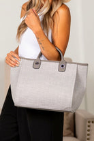 Gray canvas tote bag with clean lines, chain strap, and minimalist design