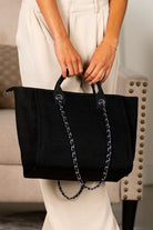 Black canvas tote bag with chain strap and top handles, clean minimalist design
