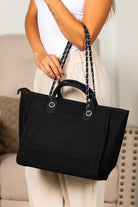 Black structured canvas tote with silver chain detail and vegan leather handles
